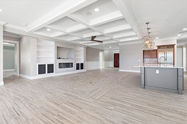 Great room with tray ceilings and built-in bookcases